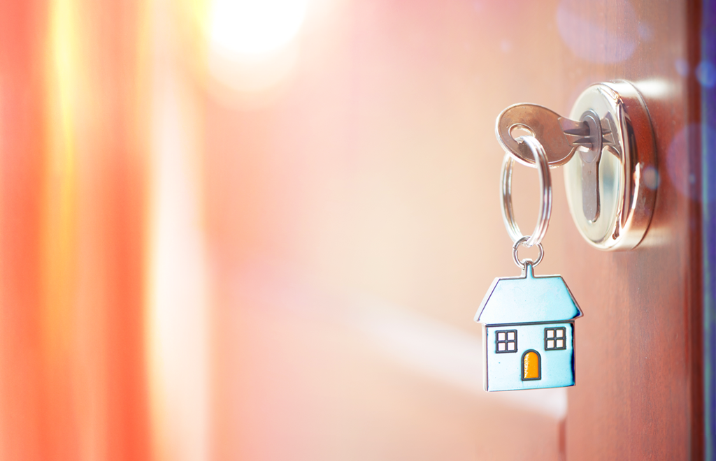 A key with a metal house keyring in a door lock